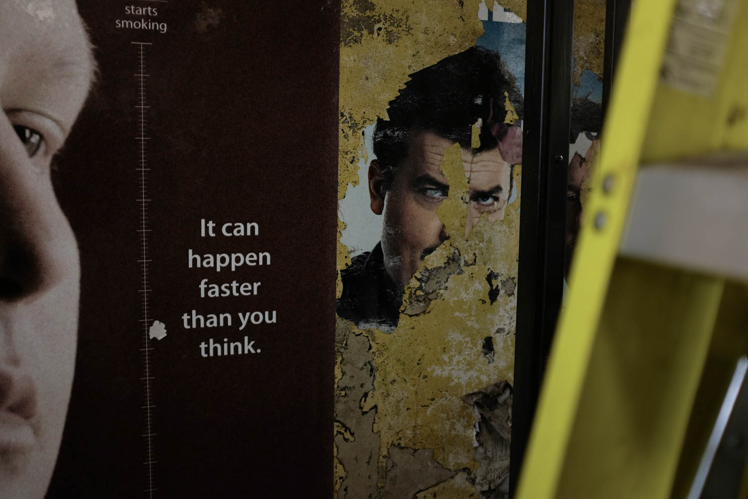 A photograph of the text "It can happen faster than you think" next to the chipped away picture of a face on an adjacent poster.