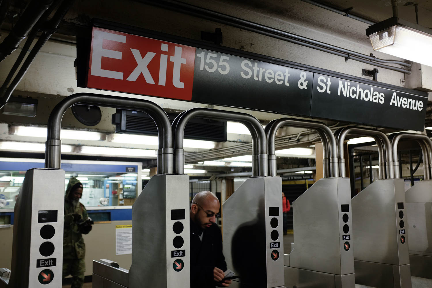 A man passing through a New York City subway turn stall.